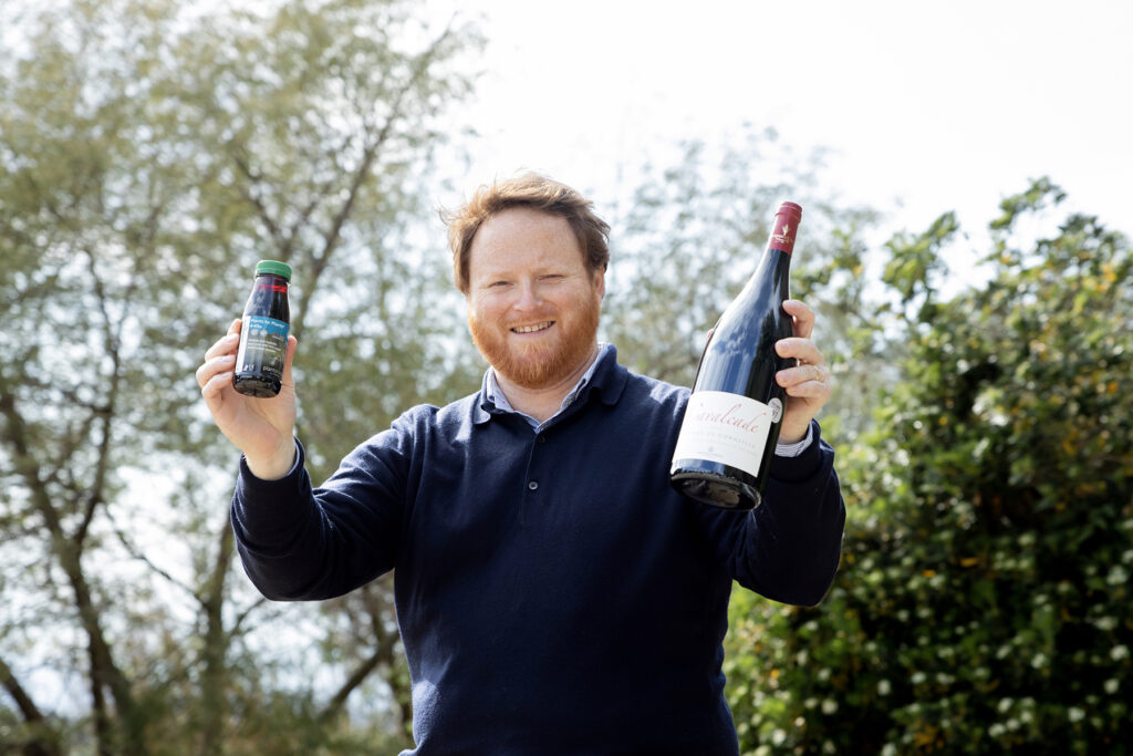 William Jonquères d'Oriola tient une bouteille de son vin et Plants for Plants 4-Vita